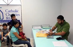 Aug. 17, 2017 - A volunteer at the Catholic Charities Humanitarian Respite Center in McAllen, Texas helps a Central American refugee family Vic Hinterlang/Shutterstock